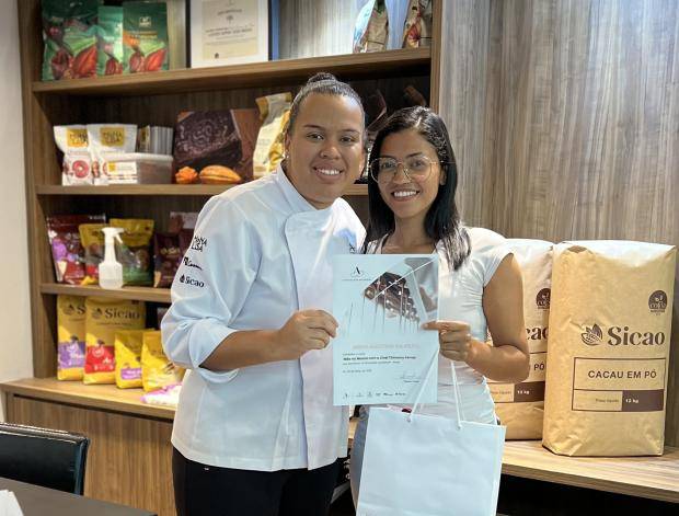 Chef entregando certificado de conclusão de curso para aluna