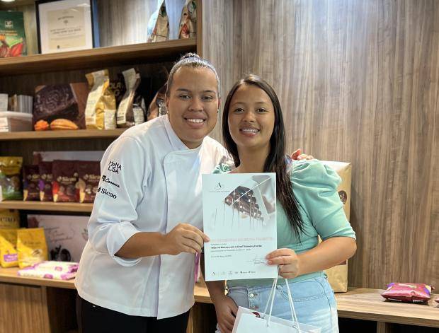 Chef entregando certificado de conclusão de curso para aluna