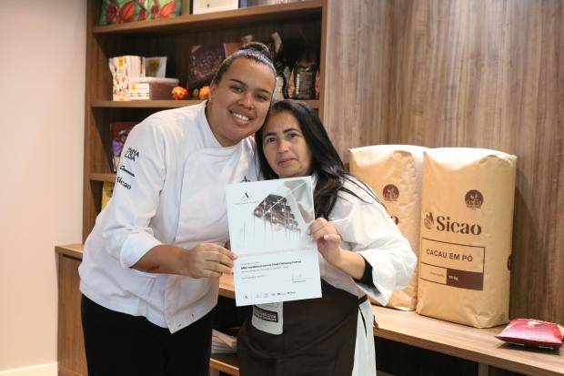 Chef entregando certificado de conclusão de curso para aluna