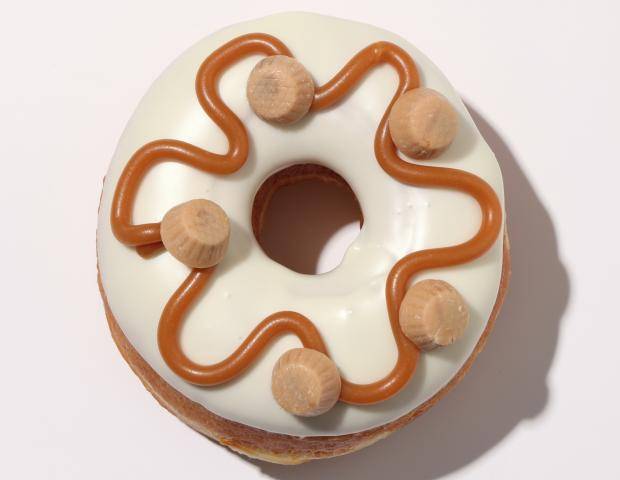 donut dipped in white ganache with a caramel drizzle